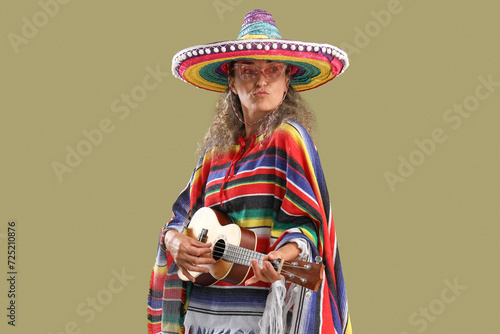 Mature woman in sombrero hat playing guitar on color background. Mexico's Day of the Dead (El Dia de Muertos) celebration