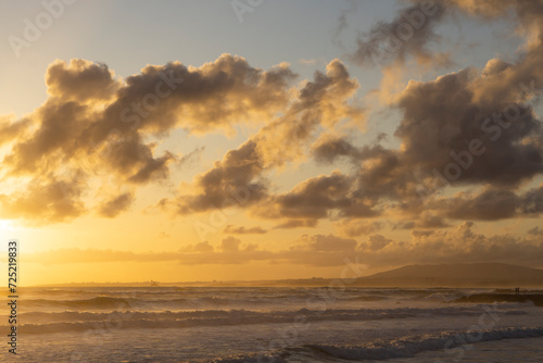 Tender ocean sunset. Sunset over the water with birds flying against sunlight on the North Atlantic ocean