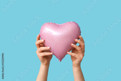 Woman with air balloon in shape of heart on blue background. Valentine s Day celebration