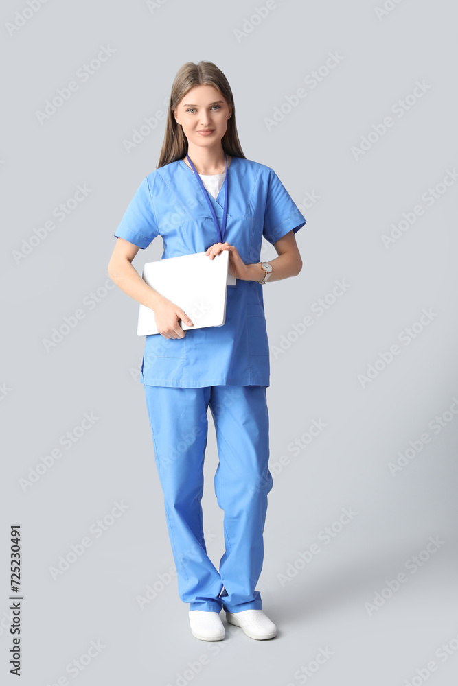 Beautiful doctor with laptop on light background Beautiful doctor with laptop on light background