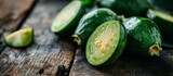 Feijoa fruits halves and cut placed on a wooden surface with selective focus.