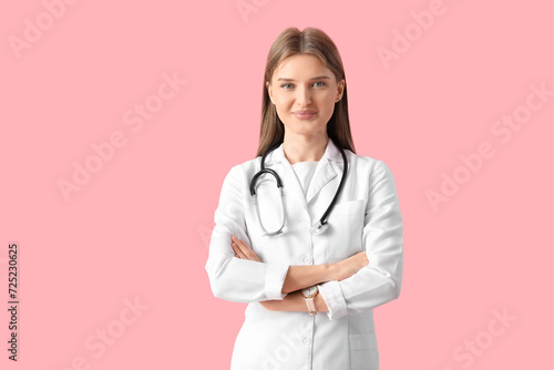 Beautiful young doctor on pink background