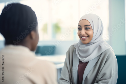 Smiling Female Doctor in Hijab Engaging with Elderly Patient in Clinic. Compassionate Healthcare, Medical Consultation Concept