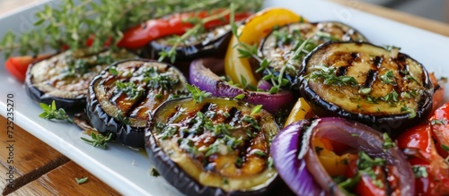 Grilled eggplant with veggies, herbs, and sauce is a vegetarian option. photo