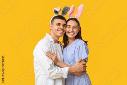 Wallpaper Mural Happy young couple with Easter bunny ears on yellow background Torontodigital.ca