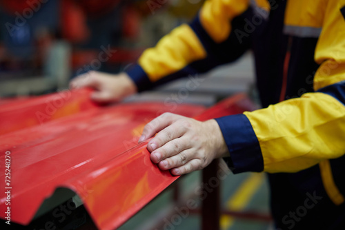 closeup worker or technician hands checking quality metal sheet from machine in the factory