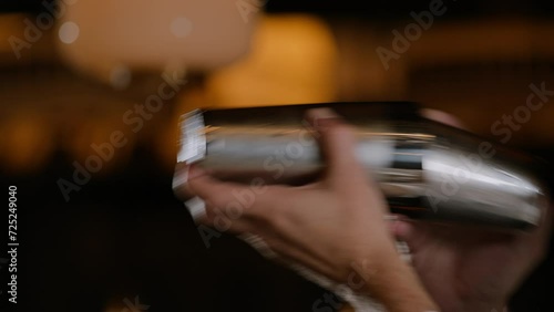 Closeup shot of a bartender shaking a cocktail in a cocktail shaker photo