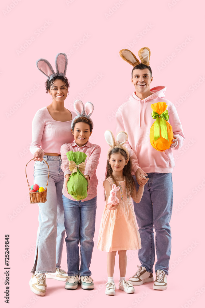 Fototapeta premium Happy family in bunny ears with Easter eggs on pink background