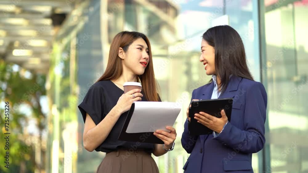 Asian business team sitting in the city using a cellphone and tablet. Asian business team sitting in the city using a cellphone and tablet.