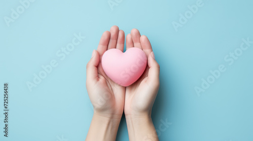 Hand hold pink heart on blue background for organ donor awareness  world heart day   a valentines day