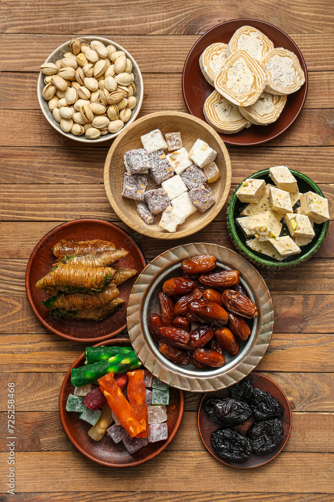 Plates with traditional Eastern sweets for Ramadan on wooden background Plates with traditional Eastern sweets for Ramadan on wooden background
