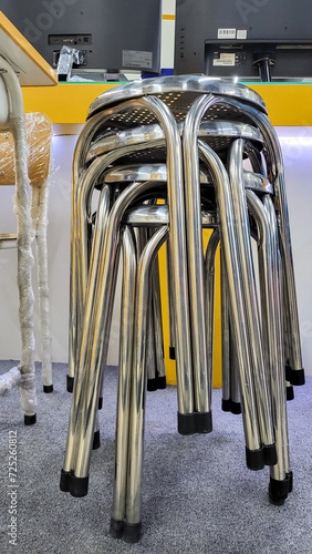 Stacked metal stools on display for sale in hardware store.