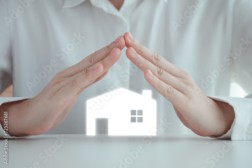 House and Property Insurance, real estate insurance agent concept. Hand covering house model from risk disaster and problem. Protection assets or family from event of damages.