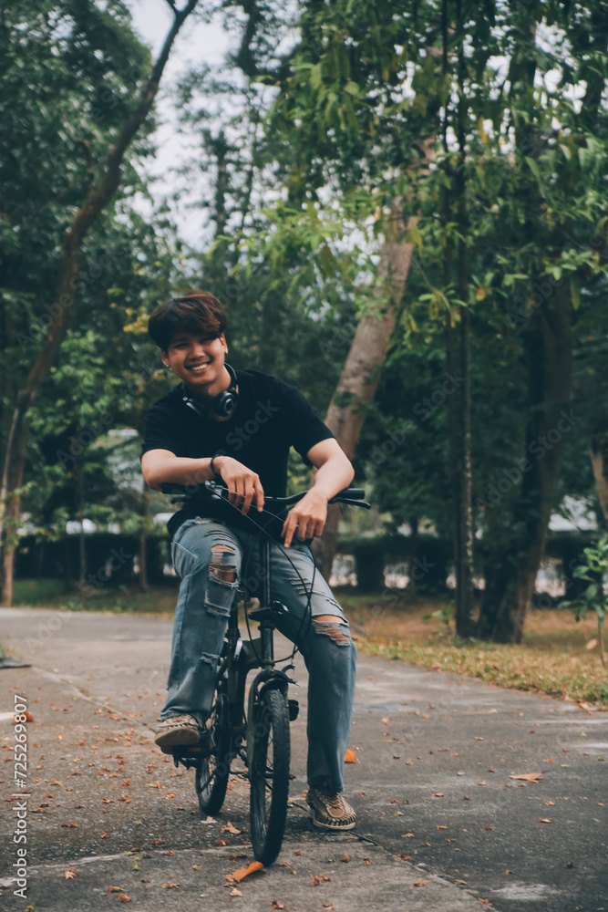 Young handsome bearded man taking a break while travelling the city with his bicycle using his digital tablet looking away thoughtfully Young handsome bearded man taking a break while travelling the city with his bicycle using his digital tablet looking away thoughtfully