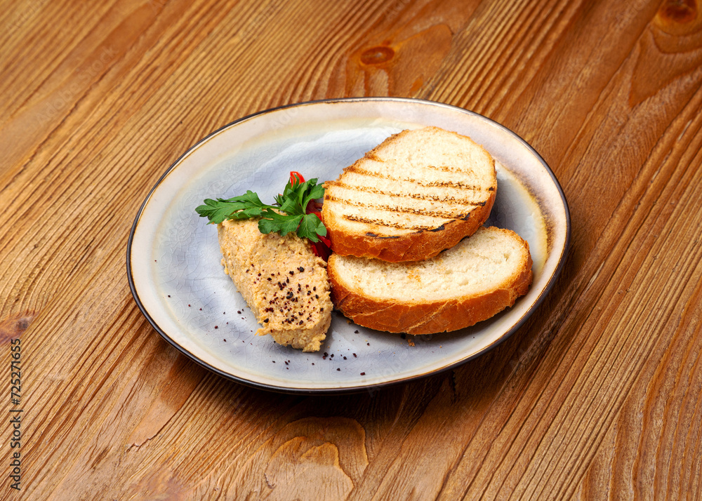 Duck meat pate with bread in a plate on a wooden background Duck meat pate with bread in a plate on a wooden background