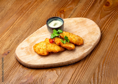 Chicken nuggets with sauce on a wooden board
