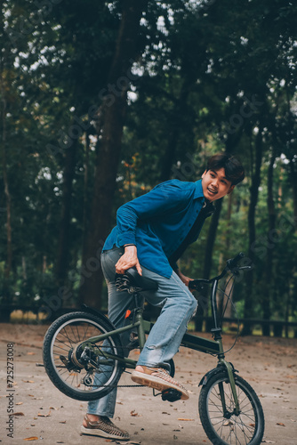 Young handsome bearded man taking a break while travelling the city with his bicycle using his digital tablet looking away thoughtfully