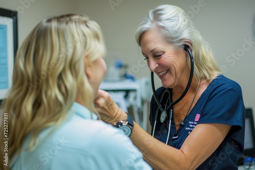 Female nurse using a stethoscope on a senior woman in the doctors office