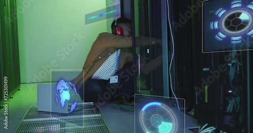 Image of data processing on screens over african american man working in server room photo