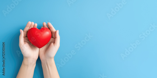 Hand hold red heart on blue background for organ donor awareness  world heart day   a valentines day