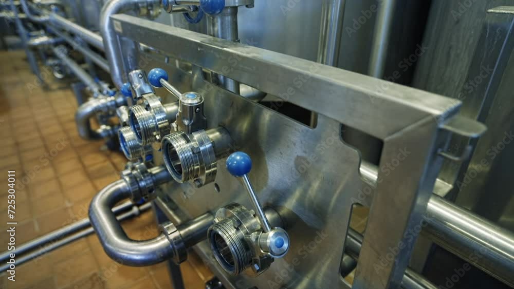 Automated line for the production of dairy products. Levers and switches. Steel equipment for dairy production. Industrial plant. Conveyor line in a modern manufacturing facility. Close up Automated line for the production of dairy products. Levers and switches. Steel equipment for dairy production. Industrial plant. Conveyor line in a modern manufacturing facility. Close up
