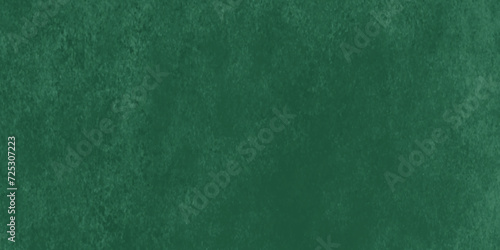 Saturated green colored low contrast Concrete textured background. Vintage lilac grunge surface backdrop. Artistic watercolor pattern on dark green.