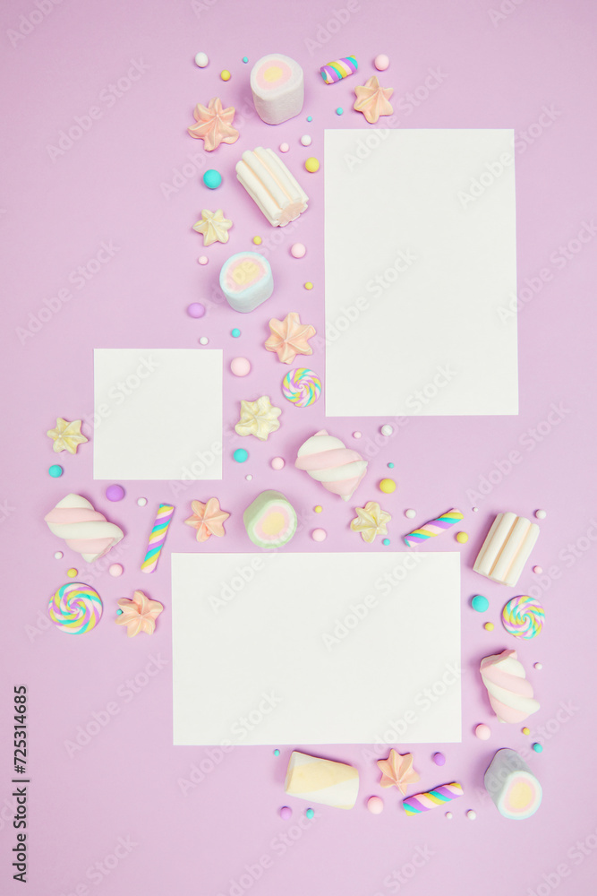 Set of three blank white cards on cute pastel purple kawaii background with frame of sweet candies, meringue and marshmallows . Flat lay, top view, copy space. Beautiful childlike design template
