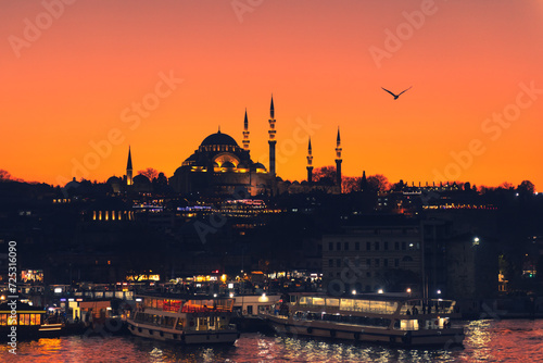 Suleymaniye Mosque and view of the Golden Horn bay at night in Istanbul, Turkey.