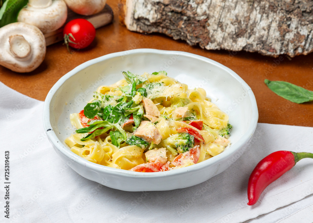 Italian pasta with salmon in a plate on a wooden background Italian pasta with salmon in a plate on a wooden background