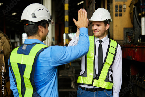 engineers or workers giving high five each other after success work and project at construction site