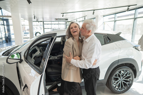 Mature Caucasian couple hugging. Elderly man and woman buying a new car.  © Михаил Решетников