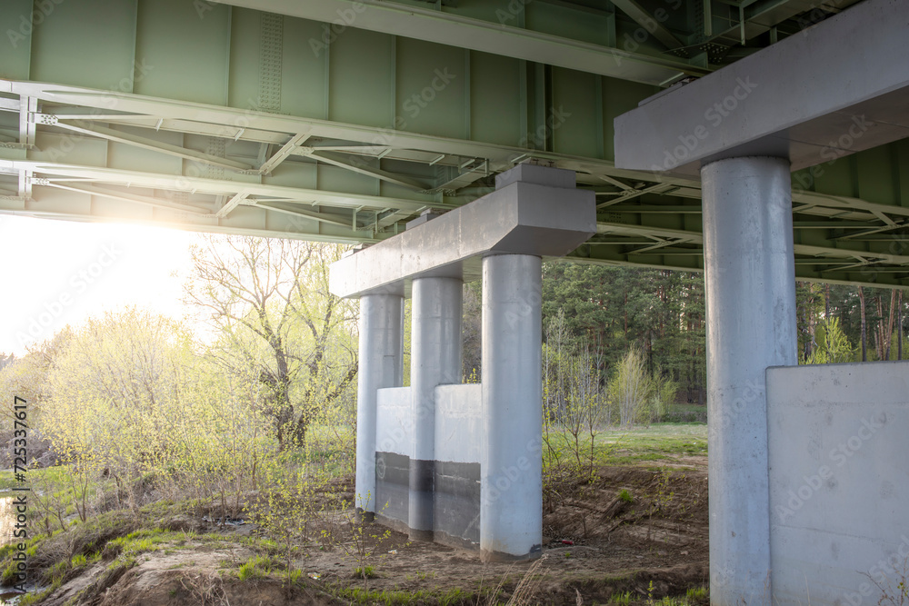 Fragment of a road bridge across the river, an iron structure on a concrete support. Fragment of a road bridge across the river, an iron structure on a concrete support.