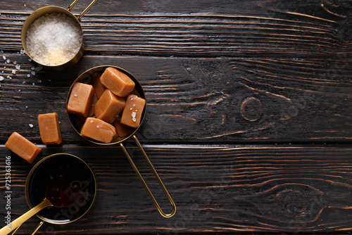 Cubes of salted caramel with salt on a wooden table