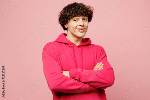 Side view young smiling happy fun Caucasian man he wears hoody casual clothes hold hands crossed folded look camera isolated on plain pastel light pink background studio portrait. Lifestyle concept