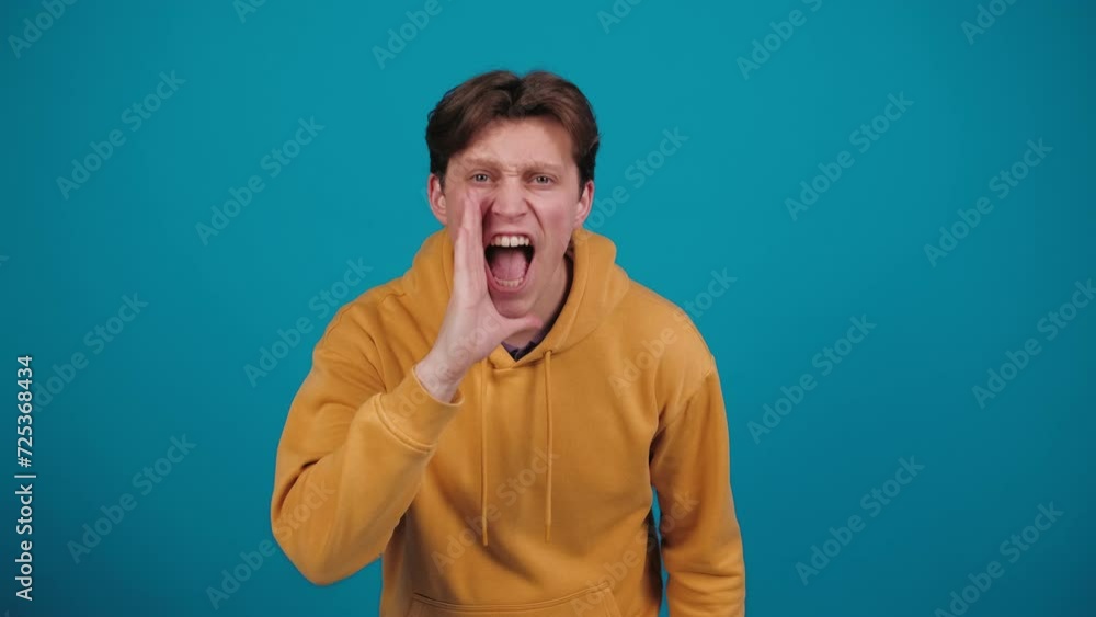 Young man scream hey on isolated studio background. Shout calling inviting with hands at mouth say hey you. Emotions. People. lifestyle Young man scream hey on isolated studio background. Shout calling inviting with hands at mouth say hey you. Emotions. People. lifestyle