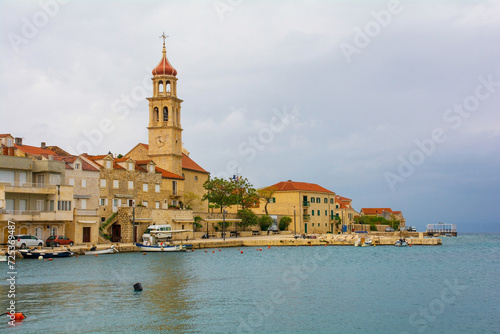 The waterfront of the historic village of Sutivan on Brac Island in Croatia. The Church of the Assumption of the Blessed Virgin Mary is centre