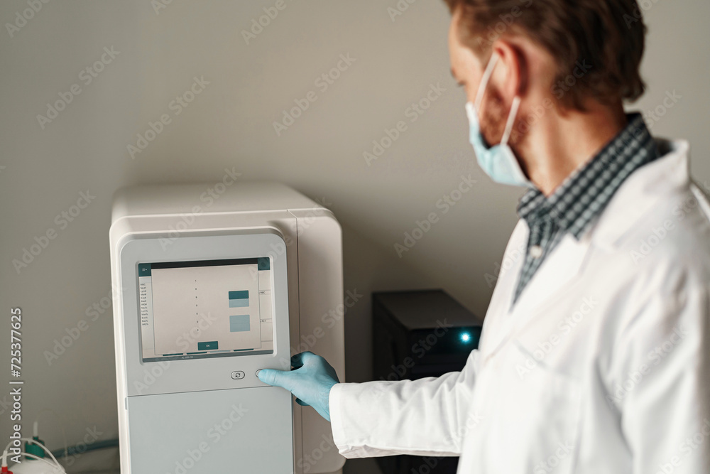 Male scientist in uniform and mask working in medical research laboratory use special equipment Male scientist in uniform and mask working in medical research laboratory use special equipment