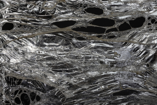 Melted Plastic Film Hole Overlay. Close-Up of Transparent Plastic Film Wrap With Textured Overlays and Shadows. 