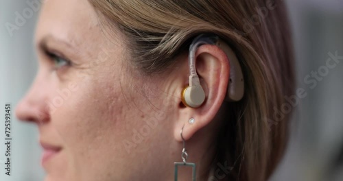 Woman wearing hearing aid on ear photo
