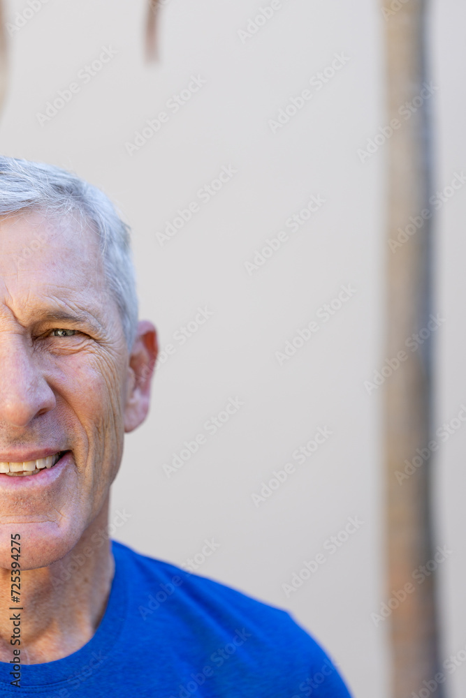 Half portrait of smiling caucasian senior man in front of grey wall with copy space Half portrait of smiling caucasian senior man in front of grey wall with copy space