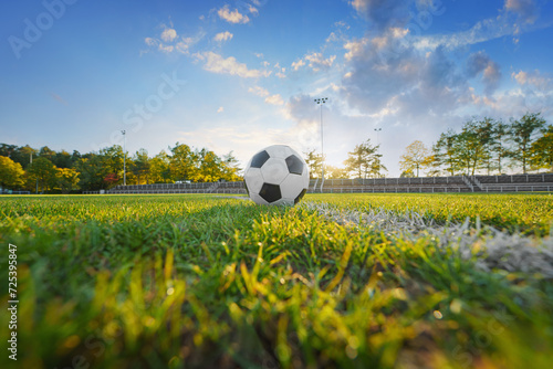 Foto ball on the green field in small soccer stadium