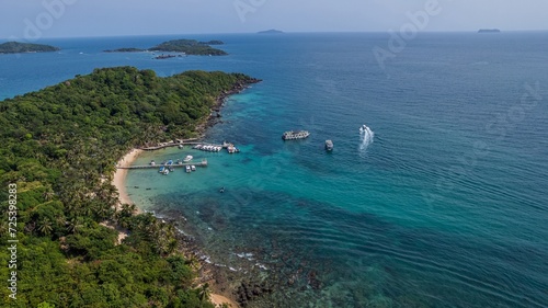Aerial view of a tropical beach with boats on a sunny day, highlighting travel and leisure activities