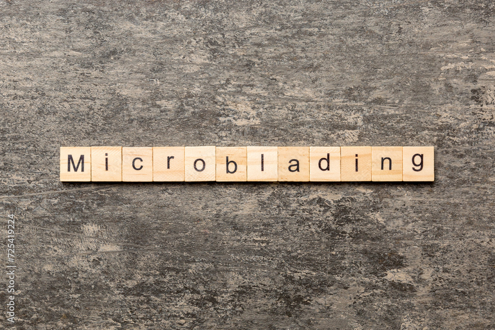 Microblading word written on wood block. Microblading text on cement table for your desing, concept