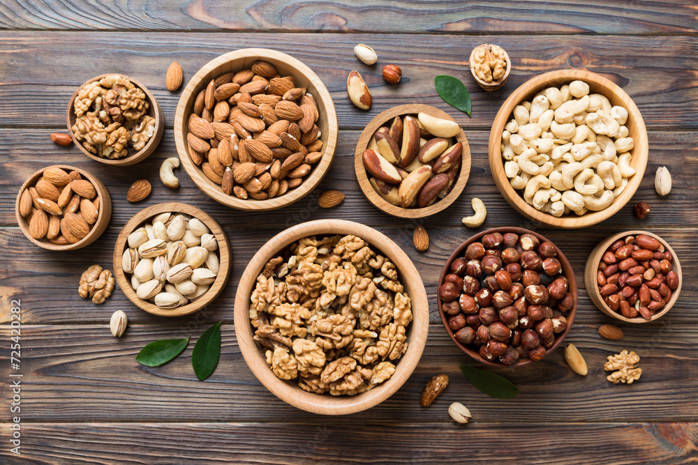 mixed nuts in wooden bowl. Mix of various nuts on colored background. pistachios, cashews, walnuts, hazelnuts, peanuts and brazil nuts mixed nuts in wooden bowl. Mix of various nuts on colored background. pistachios, cashews, walnuts, hazelnuts, peanuts and brazil nuts