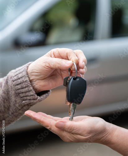 Woman giving car keys to another woman