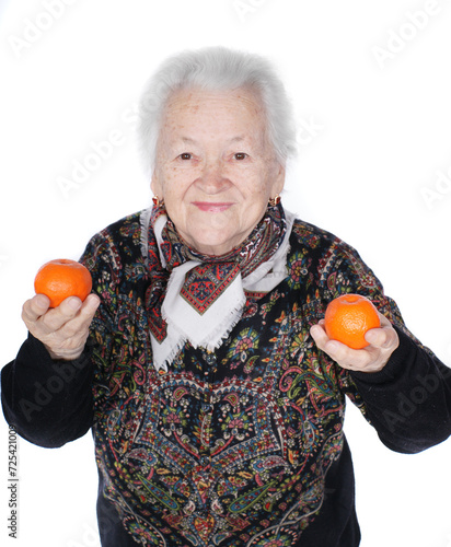 Old smiling woman hoding tangerines in hands