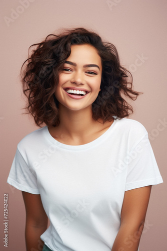 Young happy smiling Latin woman model wearing tshirt standing on color background. Face skin treatment, curly hair care cosmetics makeup, fashion ads. Beauty portrait. White t-shirt mock up template .