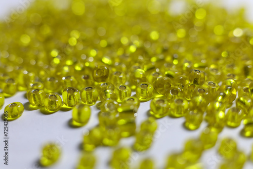 a pile of yellow glass beads on a white surface