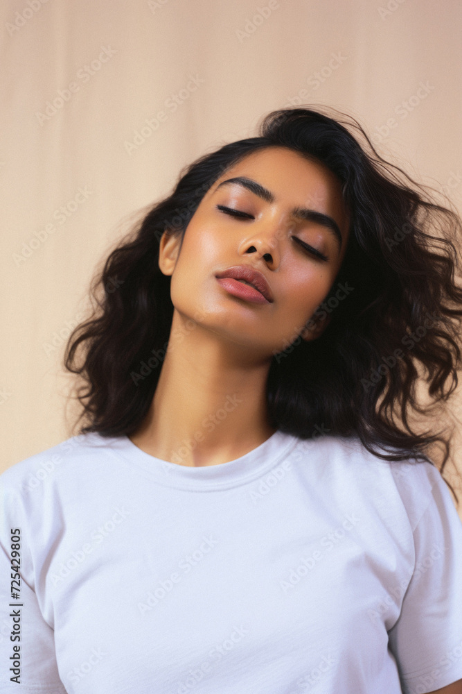 Young adult pretty Indian woman beauty model wearing white t-shirt posing with eyes closed on color background. Face flawless fresh skin hair care cosmetic treatment makeup products skincare ads . Young adult pretty Indian woman beauty model wearing white t-shirt posing with eyes closed on color background. Face flawless fresh skin hair care cosmetic treatment makeup products skincare ads .