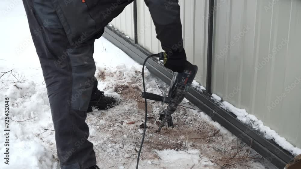 Builder Drills a hole in the wall with a Hammer Drill. Close-up of hammer drill perforator making hole Builder Drills a hole in the wall with a Hammer Drill. Close-up of hammer drill perforator making hole
